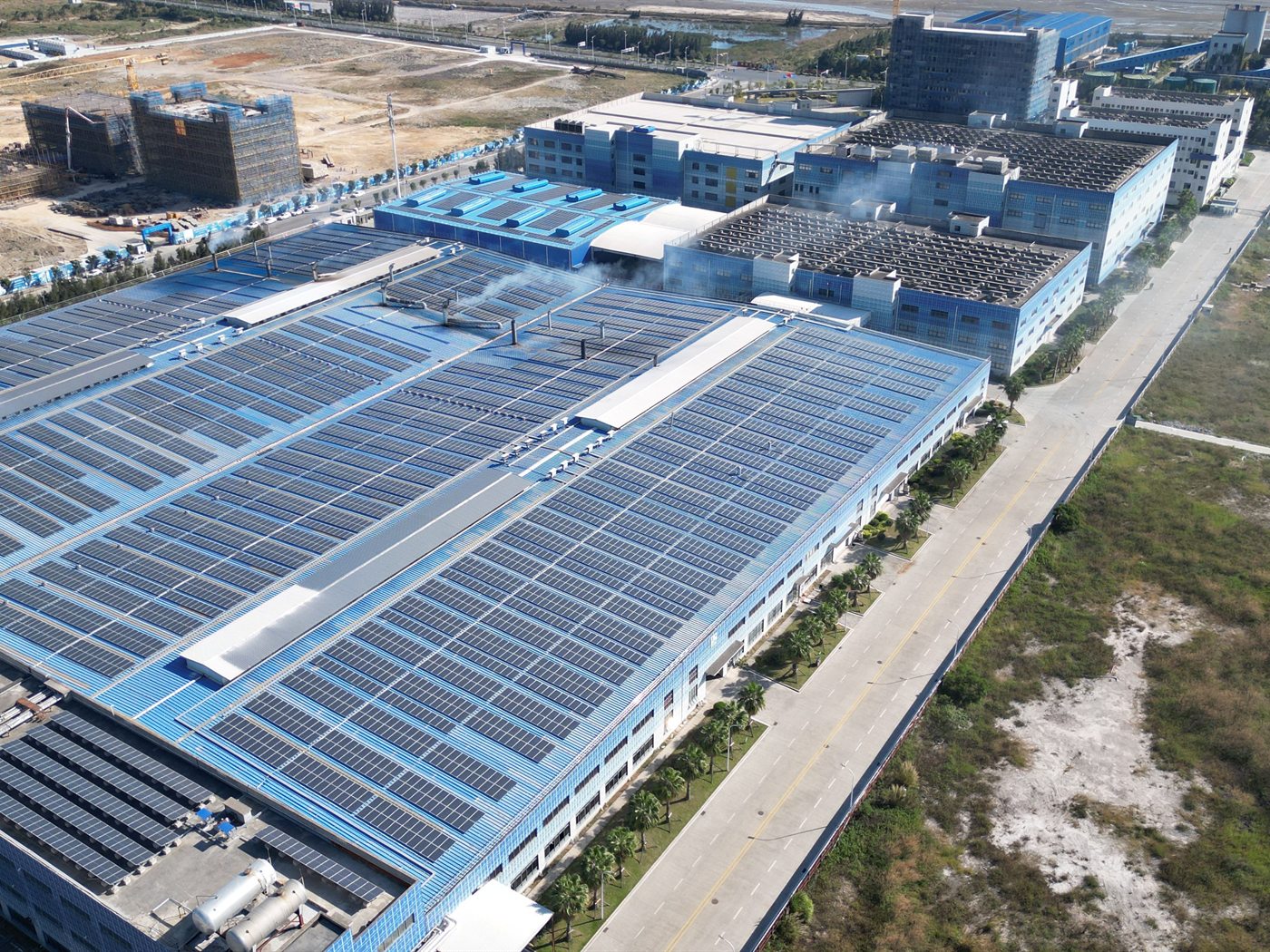 Aerial view of a factory roof covered in solar panels